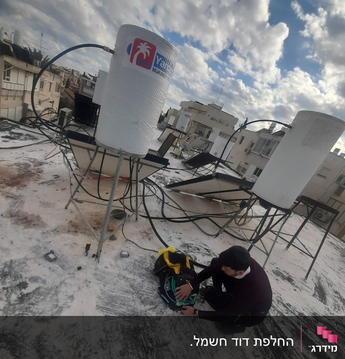 דוד שמש על גג עם אדם מתקן צנרת